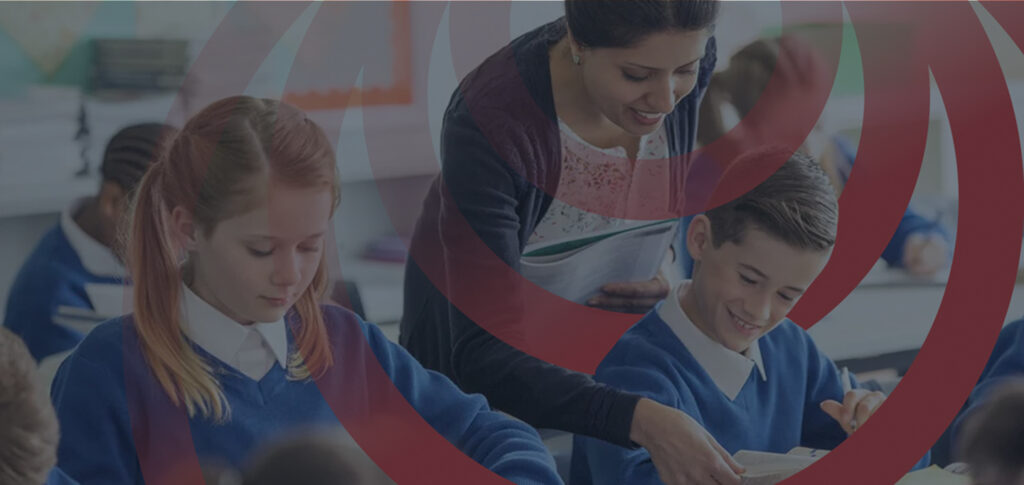 Teacher assisting students in a classroom with focus on active learning.